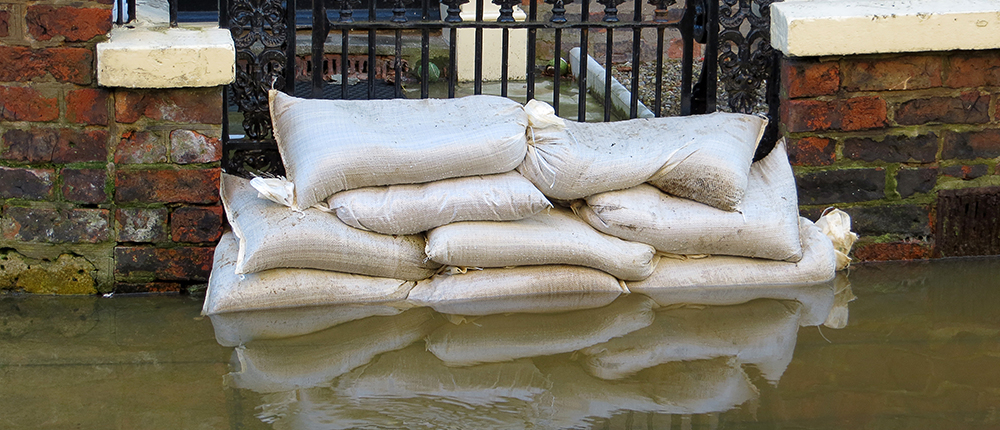 Sandbags stacked in front of house in York flooded street.