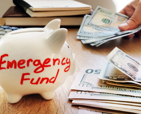 Emergency fund written on a piggy bank. The piggy bank reminds us that building a building a rainy day fund is important!