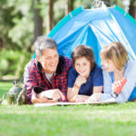 Family Studying Map While Lying In Tent