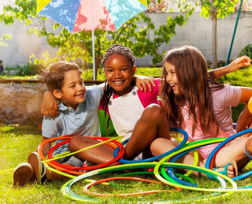 three kids enjoy a summer day with hula hoops