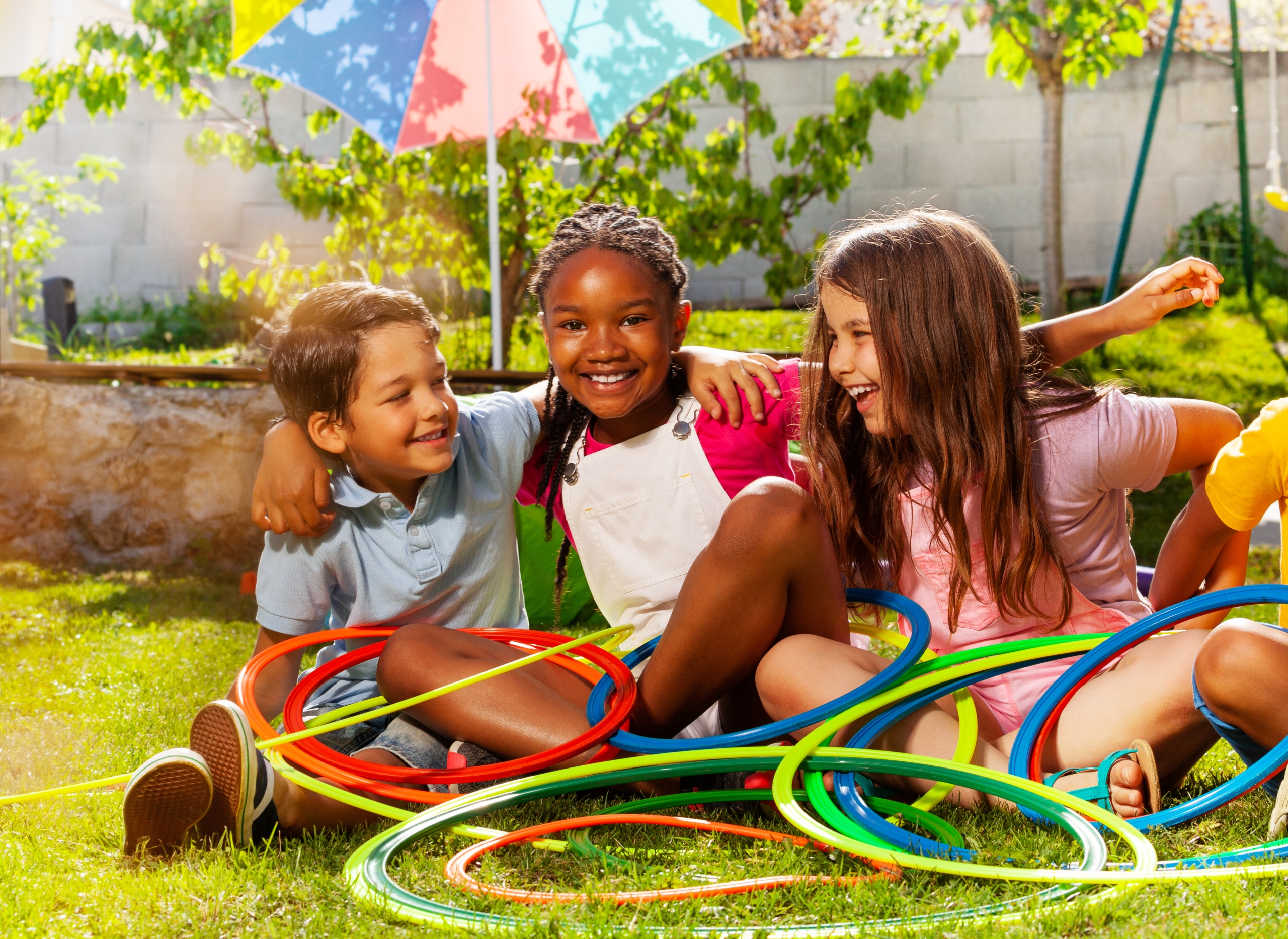 three kids enjoy a summer day with hula hoops