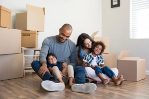 A family takes a break from packing moving boxes. Our experts provide their tips on how to prepare for a long-distance move.