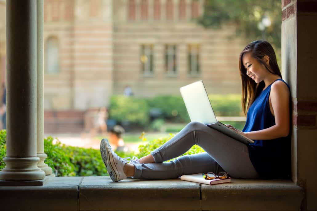 a student sits quietly to write her college essay. With the right resources writing your college essay doesn't need to be a daunting task.