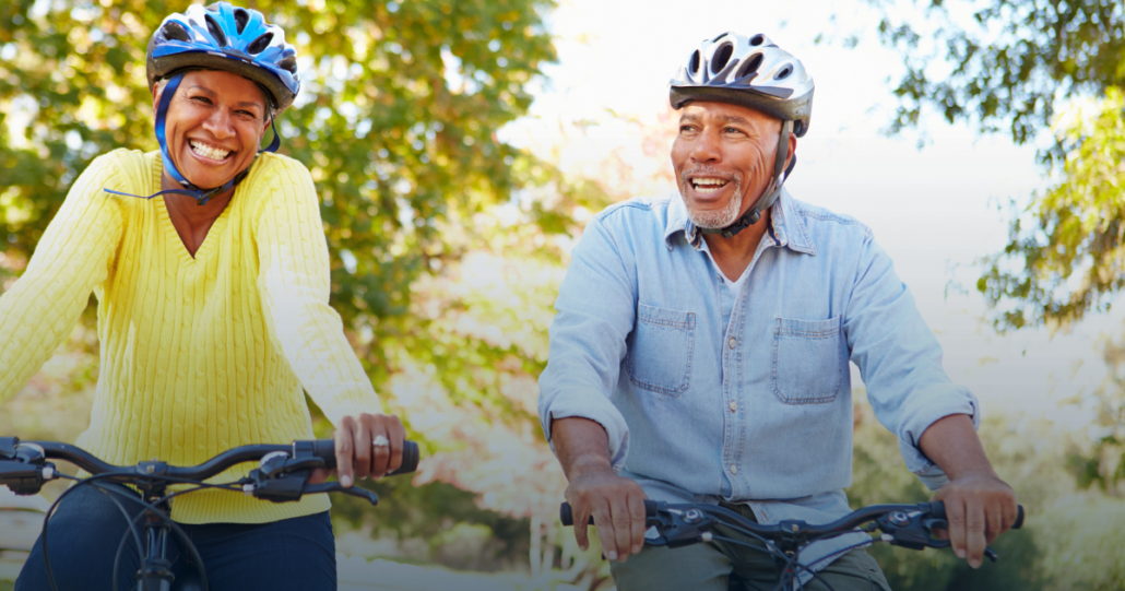 A photo of an African American couple smiling while riding bikes.