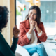 Two women talk in the office. Mentors can be an incredible source for career guidance as you explore avenues for federal career growth and career resilience.