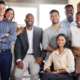 A group of diverse employees gather and smile for the camera. Labor Day is a great time to remind ourselves of the many advances we have made in the United States for rights and protections for the American Workforce.