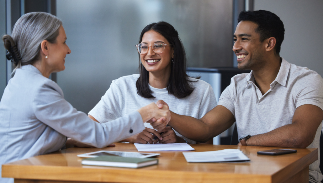 Smile, a couple and handshake with financial consultant. Happy, man and woman shaking hands of broker for finance, loan or mortgage.