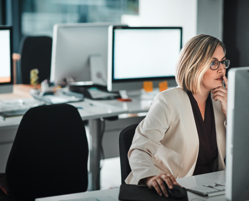 A woman works on her computer in the office. Having an email management plan can ensure an effective workflow efficiency